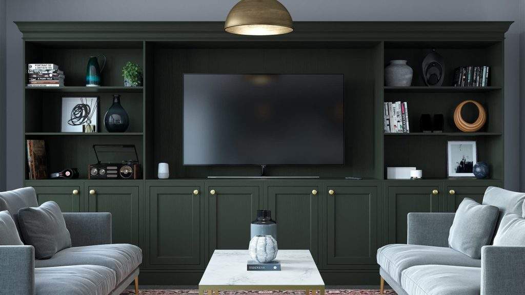 Deep Green Media Unit Featuring Bespoke Shelving And Storage Options With A Large TV Space And Grey Sofas.